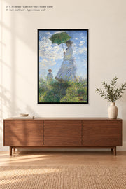 Woman with a Parasol · 24 × 36 inches · Canvas + black floater frame · room mockup · approximate scale against 60-inch sideboard